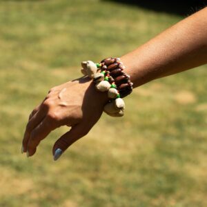 Pulsera sonajero con quince cáscaras de kenari alrededor de cuentas de madera y cuentas verdes, amarillas y rojas