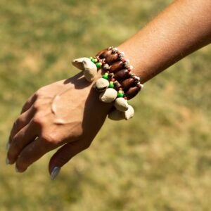 Pulsera sonajero con quince cáscaras de kenari alrededor de cuentas de madera y cuentas verdes, amarillas y rojas