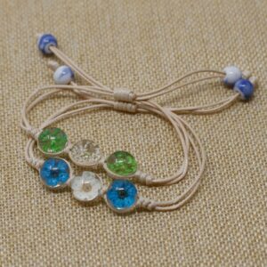 Cuatro pulseras de cordón beige con tres cúpulas de vidrio con flores secas de colores cada una