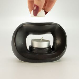Quemador de aceite de cerámica negra mate con forma de guijarro ovalado y hueco central para la vela de té