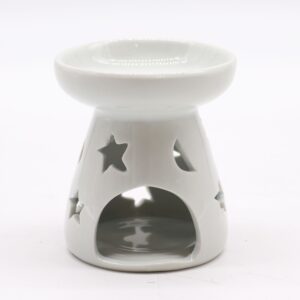 Quemador de aceite pequeño de cerámica blanca con medias lunas y estrellas caladas, sobre fondo blanco