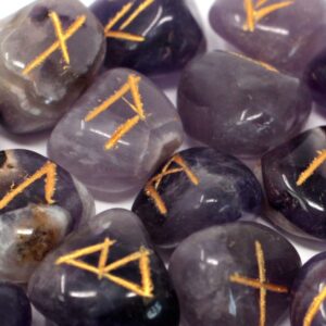 Juego de runas de amatista en tonos violeta con los signos rúnicos grabados en dorado