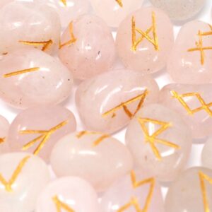 Juego de runas de cuarzo rosa pálido con los signos rúnicos grabados en dorado
