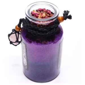 Amuleto de cuarzo rosa en red de cordón negro con cuenta de madera, junto a un frasco de sales de baño violetas