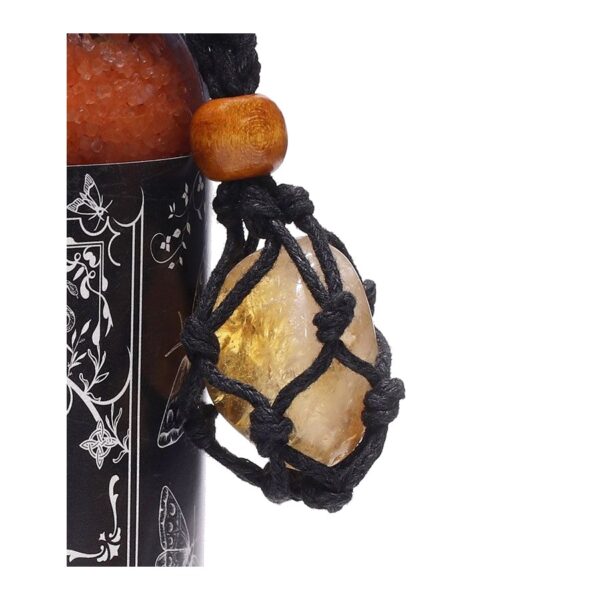 Amuleto de citrino en red de cordón negro con cuenta de madera, atado a un frasco de sales de baño naranjas