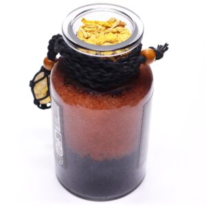 Amuleto de citrino en red de cordón negro con cuenta de madera, atado a un frasco de sales de baño naranjas