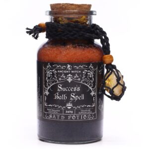 Amuleto de citrino en red de cordón negro con cuenta de madera, atado a un frasco de sales de baño naranjas