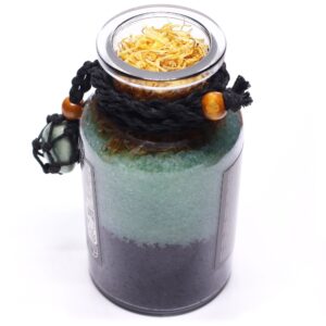 Amuleto de aventurina verde en red de cordón negro con cuenta de madera, atado a un frasco de sales de baño verdes