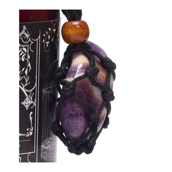 Amuleto de amatista con franjas violetas y blancas en red de cordón negro, atado a un frasco de sales de baño rojas