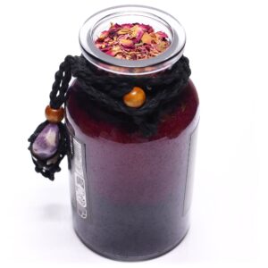 Amuleto de amatista con franjas violetas y blancas en red de cordón negro, atado a un frasco de sales de baño rojas