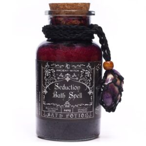 Amuleto de amatista con franjas violetas y blancas en red de cordón negro, atado a un frasco de sales de baño rojas