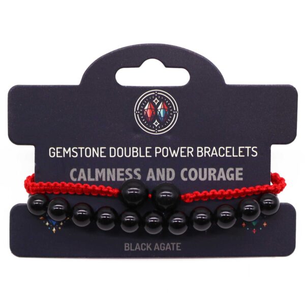 Pulsera elástica de cuentas de ágata negra y pulsera de cordón rojo trenzado con dos cuentas negras, sobre su tarjeta