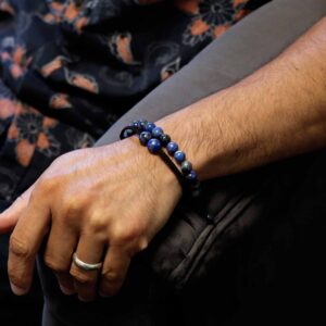 Pulsera elástica de cuentas de lapislázuli y pulsera de cordón rojo trenzado con dos cuentas de lapislázuli, sobre su tarjeta