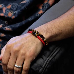 Pulsera elástica de cuentas de ojo de tigre y pulsera de cordón rojo trenzado con dos cuentas de ojo de tigre, sobre su tarjeta