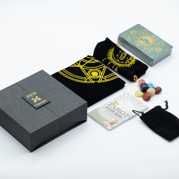 Cartas invertidas en el tarot: leerlas o no, y cómo decidirlo 2 Set de tarot con caja gris de dos puertas, baraja turquesa y dorada, tapete negro estampado en oro, bolsas de tela, piedras de colores y guía