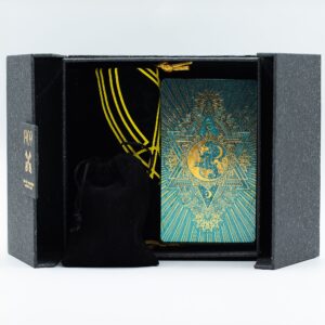 Set de tarot con caja gris de dos puertas, baraja turquesa y dorada, tapete negro estampado en oro, bolsas de tela, piedras de colores y guía
