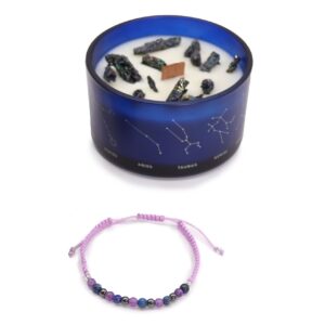 Vela de soja en vaso azul con constelaciones y trozos de pirita, junto a una pulsera de cordón lila con cuentas de amatista, lapislázuli y hematites