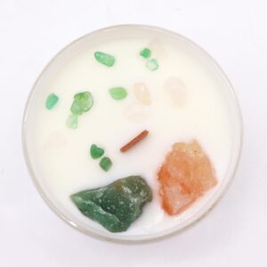 Vela del chakra del corazón en vaso blanco con cuarzo rosa y jade verde sobre la cera, apoyada en su caja verde