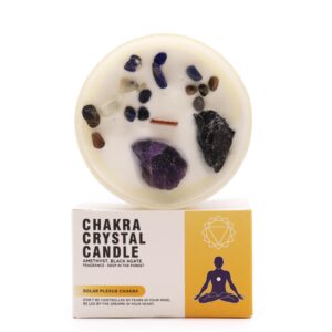 Vela del chakra del plexo solar en vaso blanco con amatista, ágata negra y lascas de colores, sobre su caja amarilla