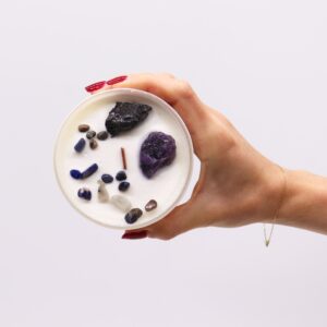 Vela del chakra del plexo solar en vaso blanco con amatista, ágata negra y lascas de colores, sobre su caja amarilla