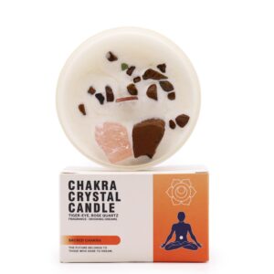 Vela del chakra sacro en vaso blanco con cuarzo rosa y ojo de tigre sobre la cera, apoyada en su caja naranja