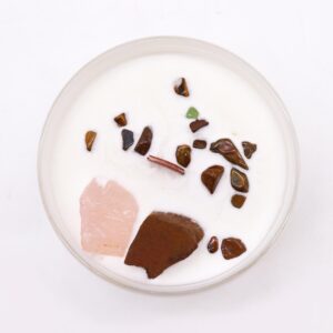 Vela del chakra sacro en vaso blanco con cuarzo rosa y ojo de tigre sobre la cera, apoyada en su caja naranja