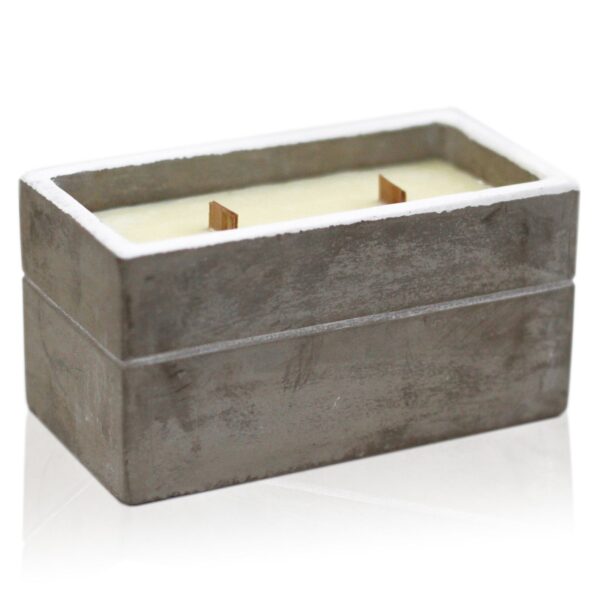 Vela rectangular en caja de hormigón gris con dos mechas de madera encendidas