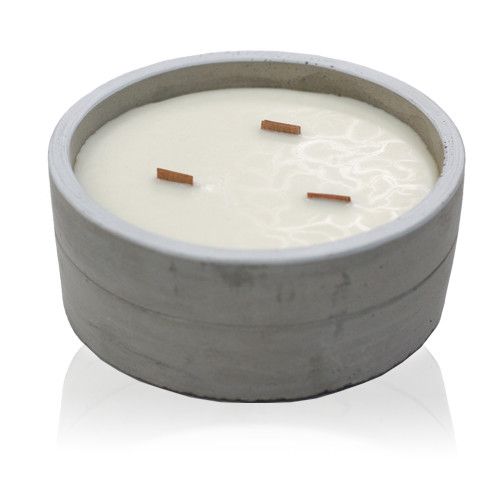 Vela redonda en cuenco de hormigón gris con tres mechas de madera