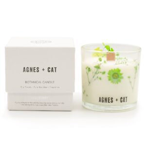 Vela de soja en vaso de vidrio con flores secas verdes junto a su caja blanca