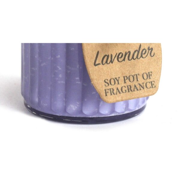 Vela de soja de color lila en tarro de cristal estriado con etiqueta kraft que dice Lavender