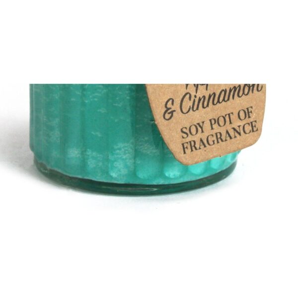 Vela de soja de color verde turquesa en tarro de cristal estriado con etiqueta kraft que dice Apple & Cinnamon