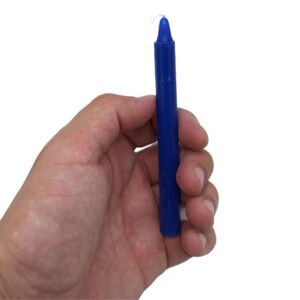 Caja de velas azul oscuro del chakra del tercer ojo abierta, con varias velas finas dentro y una vela fuera