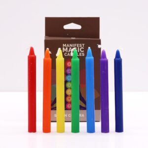 Siete velas finas de los colores de los chakras, de pie en fila del rojo al azul oscuro y violeta, delante de su caja